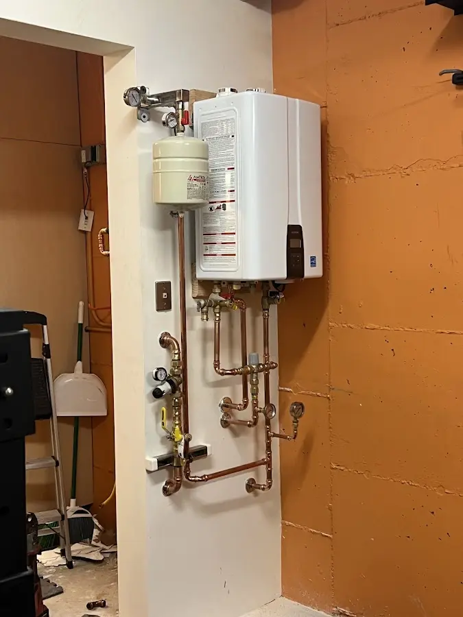 Plumbing technician inspecting water heater connections in Gantt
